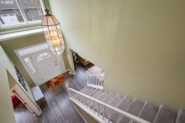 entryway featuring stairway, wood finished floors, and a towering ceiling