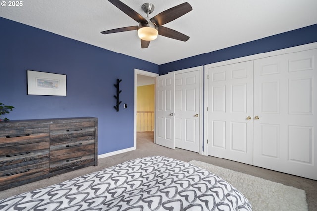 carpeted bedroom with a ceiling fan, baseboards, and multiple closets