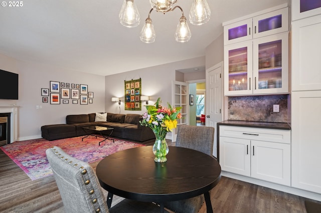 dining room with dark wood finished floors and a fireplace