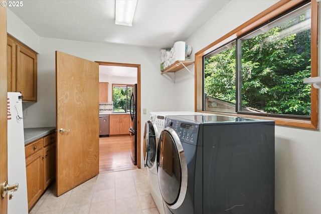 18194 Shady Hollow Way W, Linn, OR 97068 - laundry room featuring washing machine and clothes dryer, cabinet space, and light tile patterned flooring
