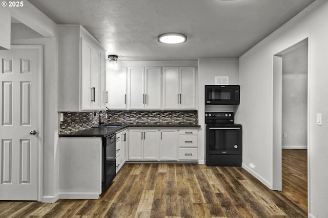1262 Kalmia St, Junction City, OR 97448 - kitchen with a sink, dark countertops, black appliances, and white cabinetry
