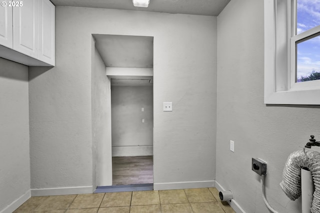 1262 Kalmia St, Junction City, OR 97448 - clothes washing area featuring baseboards, light tile patterned flooring, electric dryer hookup, and cabinet space