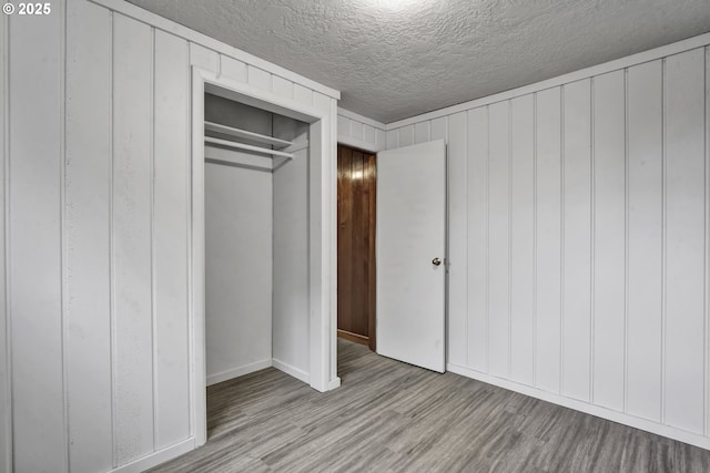 1262 Kalmia St, Junction City, OR 97448 - unfurnished bedroom with baseboards, a textured ceiling, wood finished floors, and a closet