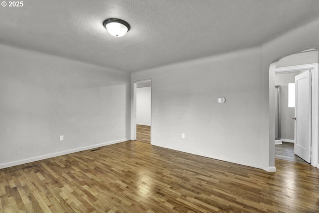 1262 Kalmia St, Junction City, OR 97448 - spare room with visible vents, wood finished floors, baseboards, a textured ceiling, and arched walkways