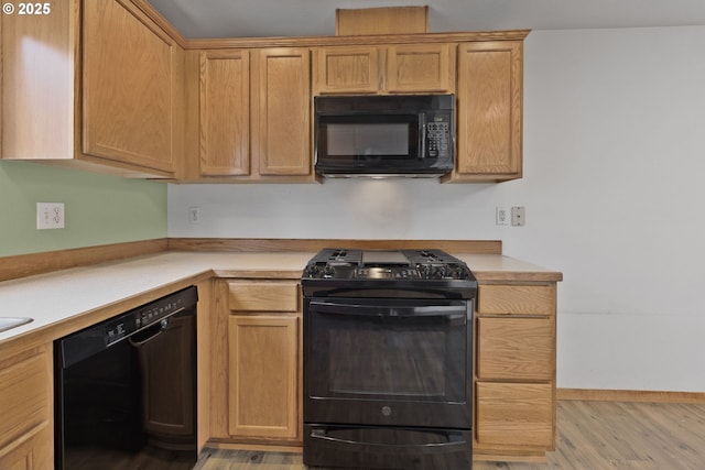 263 Ferndale Dr, Eugene, OR 97404 - kitchen with black appliances, light wood finished floors, light countertops, and baseboards