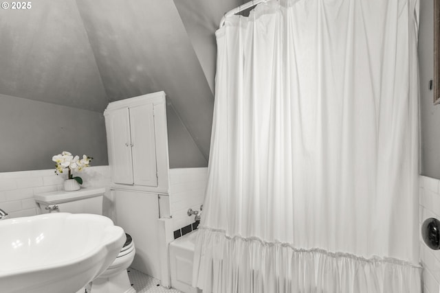 1067 Oak St, Silverton, OR 97381 - bathroom with tile walls, toilet, lofted ceiling, a sink, and wainscoting