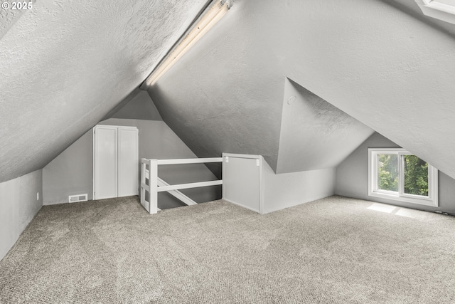 1067 Oak St, Silverton, OR 97381 - additional living space featuring a textured ceiling, vaulted ceiling, and carpet