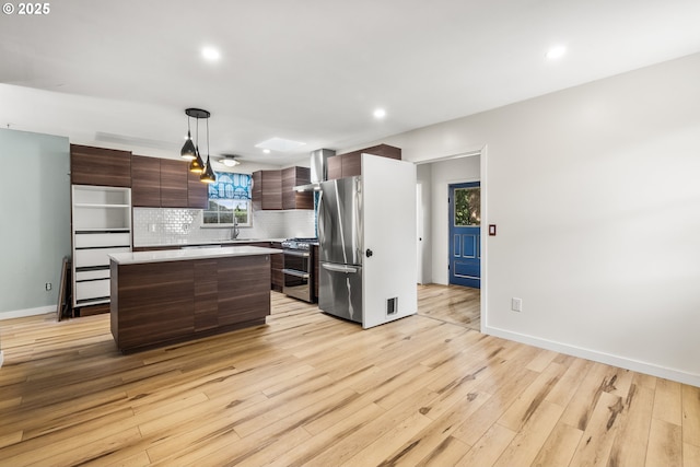 1067 Oak St, Silverton, OR 97381 - kitchen featuring appliances with stainless steel finishes, light countertops, tasteful backsplash, light wood-style floors, and recessed lighting