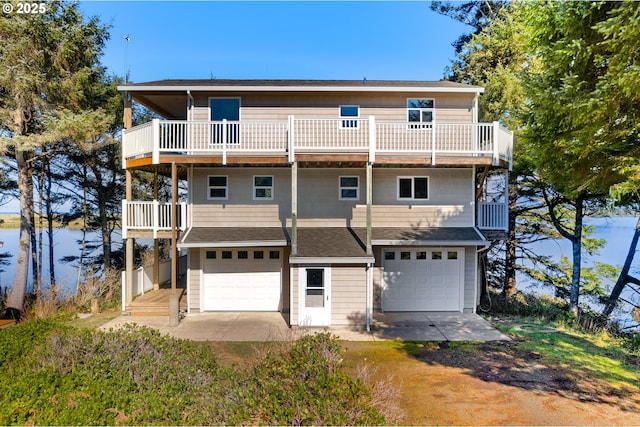 rear view of house featuring a garage and a balcony