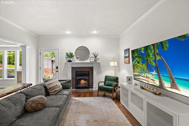 1498 Cathlamet Ct, Salem, OR 97304 - living room featuring a fireplace with flush hearth, dark wood finished floors, a textured ceiling, ornamental molding, and recessed lighting