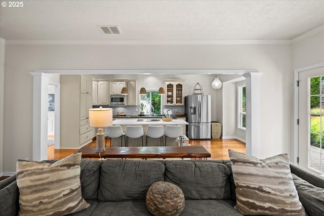 1498 Cathlamet Ct, Salem, OR 97304 - living area featuring light wood-type flooring, ornamental molding, and a textured ceiling