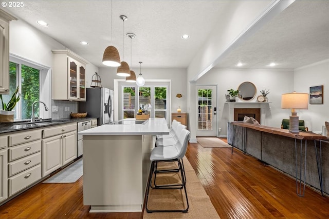1498 Cathlamet Ct, Salem, OR 97304 - kitchen with open floor plan, a sink, stainless steel fridge, glass insert cabinets, and dark wood-style floors