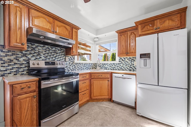 719 6th St, Astoria, OR 97103 - kitchen with white appliances, under cabinet range hood, a sink, light countertops, and brown cabinetry