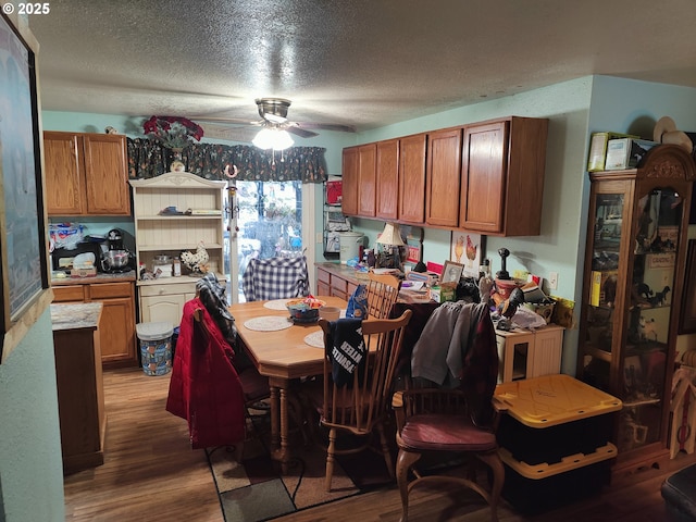 dining room featuring hardwood / wood-style floors, a textured ceiling, and ceiling fan