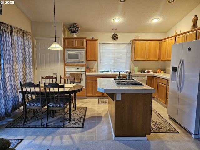 kitchen featuring a sink, a textured ceiling, tile countertops, white appliances, and a kitchen island