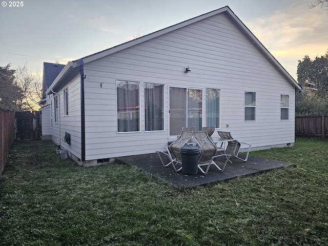 back house at dusk with a lawn