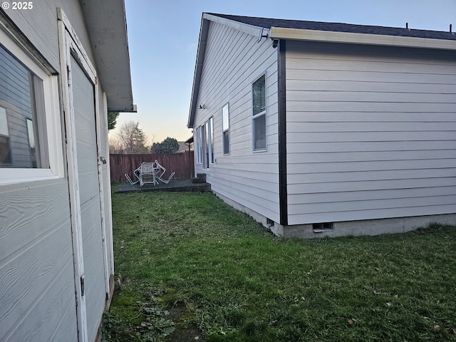 property exterior at dusk featuring a yard