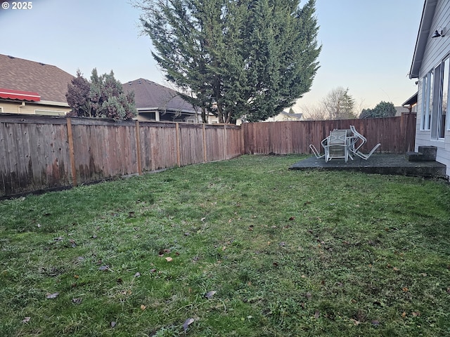 yard at dusk featuring a patio