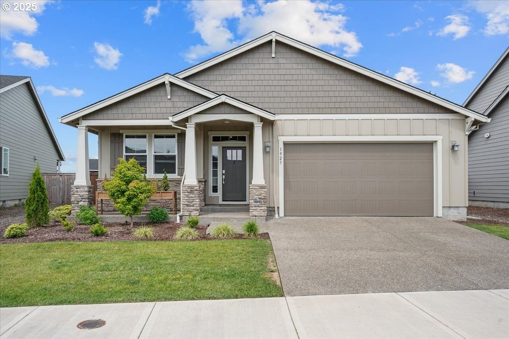 1925 N Ivy St, Canby, OR 97013 - craftsman inspired home with stone siding, driveway, a garage, a front yard, and board and batten siding