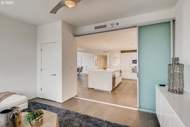 living room with light wood-type flooring and ceiling fan