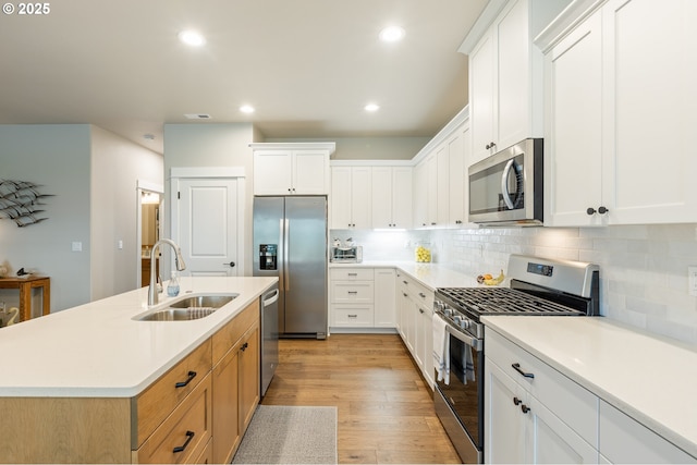 847 Pebble Crk St, Sutherlin, OR 97479 - kitchen featuring stainless steel appliances, a sink, light wood-style flooring, tasteful backsplash, and a kitchen island with sink