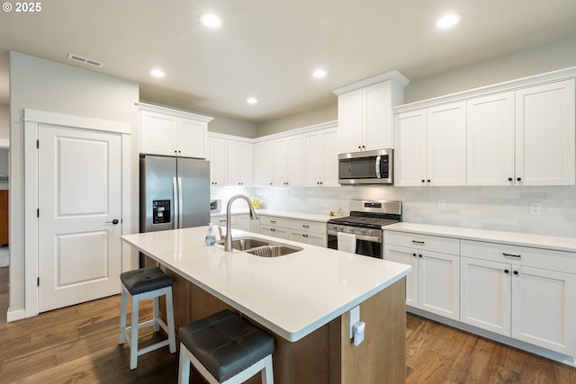 847 Pebble Crk St, Sutherlin, OR 97479 - kitchen with stainless steel appliances, a sink, decorative backsplash, a kitchen breakfast bar, and white cabinetry