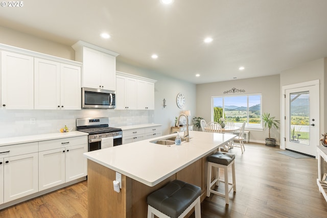 847 Pebble Crk St, Sutherlin, OR 97479 - kitchen featuring stainless steel appliances, a sink, a center island with sink, decorative backsplash, and a kitchen breakfast bar