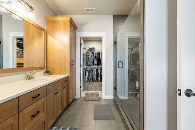 847 Pebble Crk St, Sutherlin, OR 97479 - bathroom featuring vanity, a spacious closet, tile patterned flooring, and a shower stall