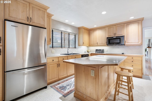 kitchen featuring black appliances, light brown cabinetry, and a sink