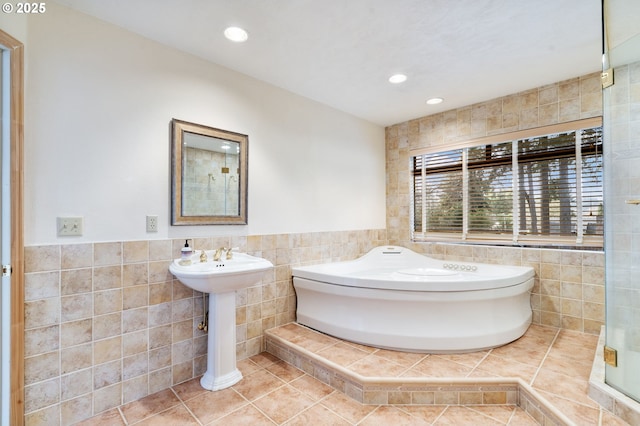 bathroom with tile patterned flooring, a garden tub, tile walls, and recessed lighting