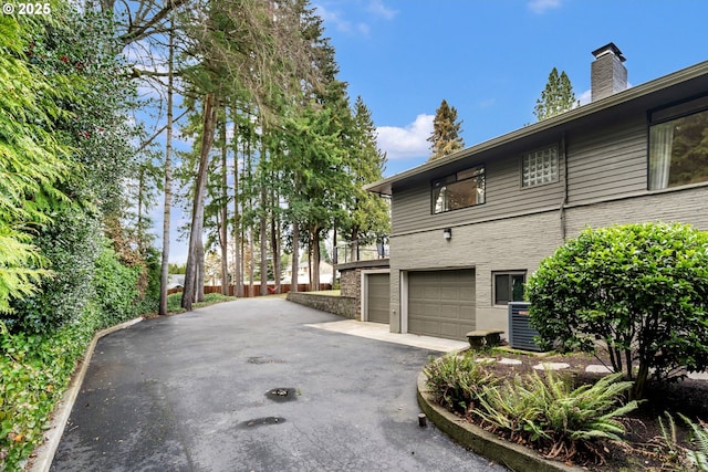 view of property exterior featuring driveway and a garage