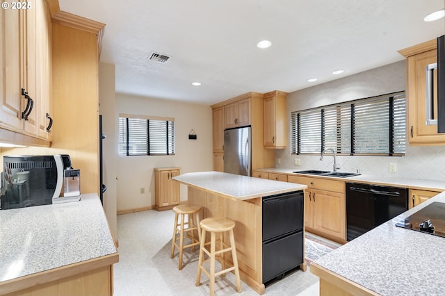 kitchen featuring black appliances, light brown cabinetry, a sink, and visible vents