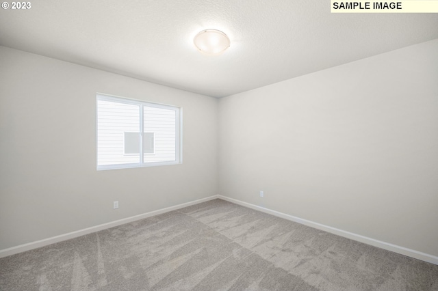 carpeted spare room with baseboards