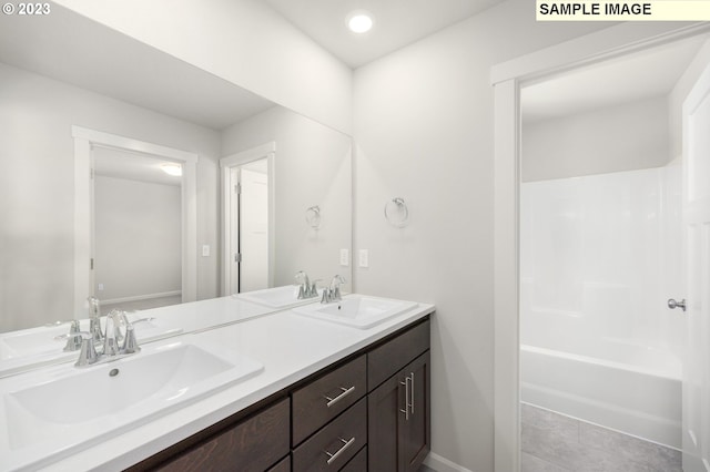 full bathroom featuring double vanity, a sink, and baseboards