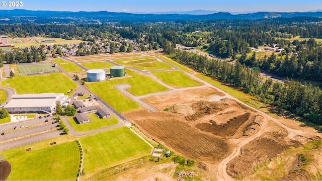 drone / aerial view with a wooded view and a mountain view