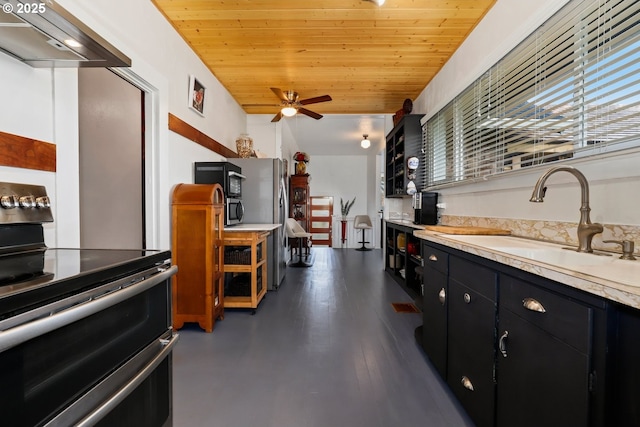 44409 SW Knight Rd, Gaston, OR 97119 - kitchen featuring range with two ovens, dark cabinets, under cabinet range hood, a sink, and light countertops