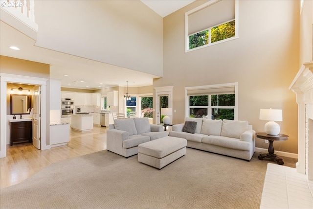 980 SW 7th St, Dundee, OR 97115 - living room featuring a towering ceiling, recessed lighting, light carpet, light wood finished floors, and a fireplace