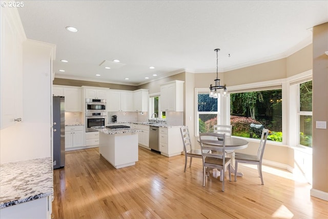 980 SW 7th St, Dundee, OR 97115 - kitchen with appliances with stainless steel finishes, ornamental molding, healthy amount of natural light, a chandelier, and white cabinetry