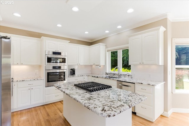 980 SW 7th St, Dundee, OR 97115 - kitchen with appliances with stainless steel finishes, white cabinetry, ornamental molding, light wood-style flooring, and tasteful backsplash
