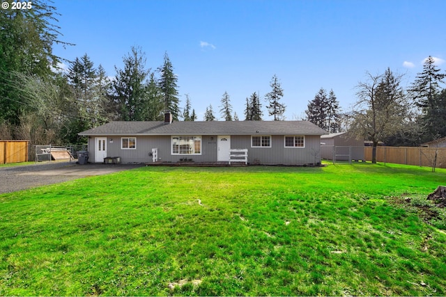 single story home featuring driveway, a front yard, and fence