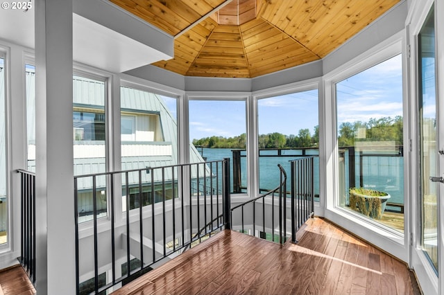 sunroom / solarium with wood ceiling, a healthy amount of sunlight, and hardwood / wood-style flooring