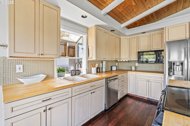 kitchen featuring black microwave, stainless steel fridge, a sink, wood counters, and electric stove