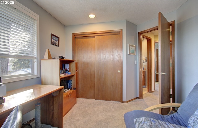 carpeted home office featuring a textured ceiling