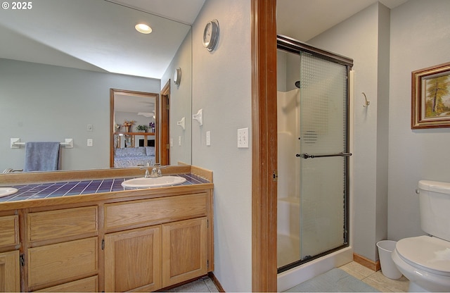 bathroom with vanity, toilet, tile patterned flooring, and a shower with door