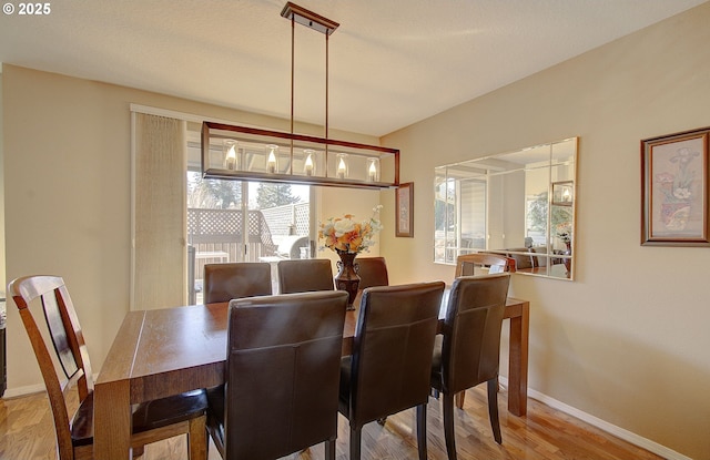 dining space with wood-type flooring