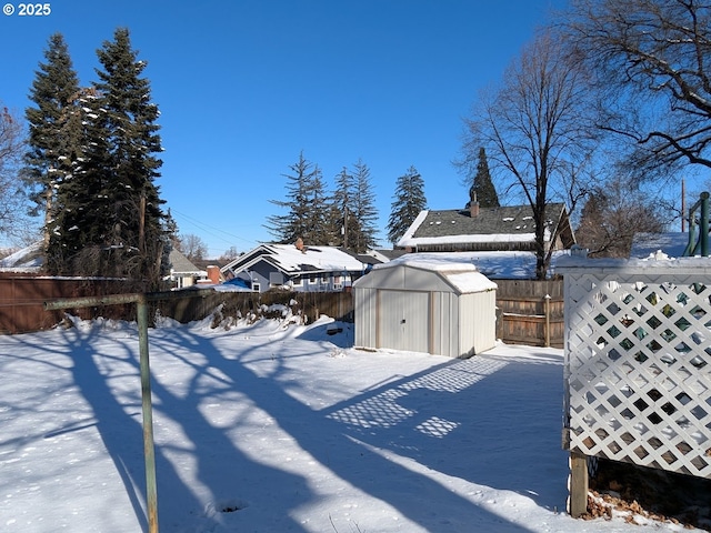 yard covered in snow with a storage shed