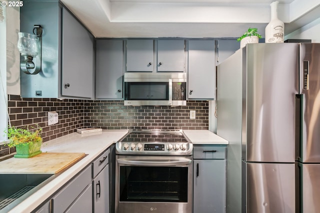 2818 Treetop Ln, West Linn, OR 97068 - kitchen with appliances with stainless steel finishes, gray cabinets, and decorative backsplash