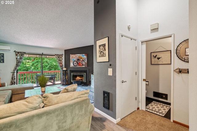 2818 Treetop Ln, West Linn, OR 97068 - living room with a lit fireplace, a wall mounted air conditioner, baseboards, a textured ceiling, and heating unit