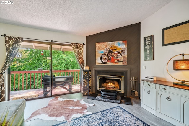 2818 Treetop Ln, West Linn, OR 97068 - living area featuring a textured ceiling, wood finished floors, and a glass covered fireplace