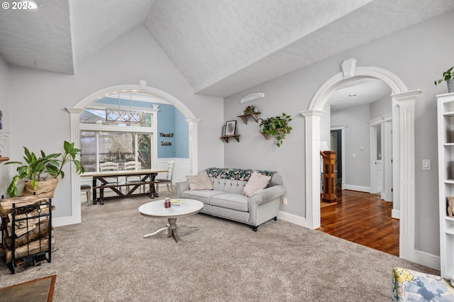 living room with decorative columns, arched walkways, and carpet